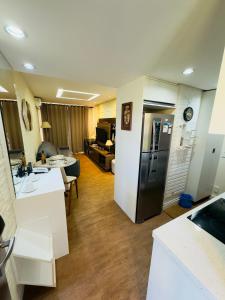 eine Küche und ein Wohnzimmer mit einem Kühlschrank in der Unterkunft Brasília - Lakeside Apartamento in Brasilia