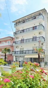 a tall building with balconies and flowers in front of it at Giannis Hotel in Paralia Katerinis