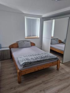 a bedroom with a wooden bed and two windows at Gasthaus Sonne 3 in Braunsbach