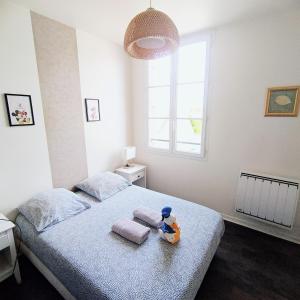 un animal de peluche sentado en una cama en un dormitorio en Appartement Le Petit Monde Magique, en Bailly-Romainvilliers