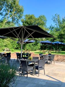 a group of tables and chairs with umbrellas at The Bowl Inn in Charing