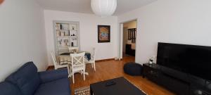 a living room with a blue couch and a table at Le petit du Barry in Millau