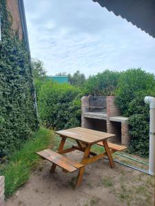 un tavolo da picnic in legno di fronte a un forno in mattoni di Cabañas Sueño Serrano a Saldungaray