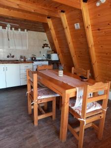 una cucina con tavolo e sedie in legno di Cabañas Sueño Serrano a Saldungaray