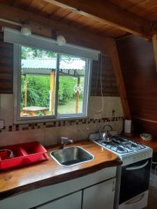 una cucina con un lavandino e una finestra di Cabañas Sueño Serrano a Saldungaray
