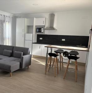 a living room with a couch and a table and chairs at Apartamentos Élan in Olvera +6 photos