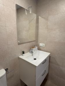 a bathroom with a white sink and a mirror at Apartamentos Élan in Olvera