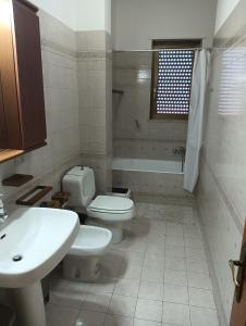 a white bathroom with a toilet and a sink at Casa Luciana in Maglie +4 photos