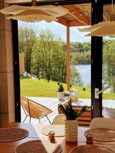 a table with chairs and a view of a patio at Stodoła Rzym - domek, jacuzzi, sauna, jezioro, las in Kożyczkowo