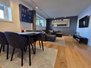 un salon avec une table et un canapé dans l'établissement BRUNØST APARTMENT modern apartment close to city center with free parking, à Tromsø