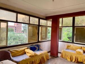 a room with two beds and windows in it at بيت الريف المصرى in Shunūfah