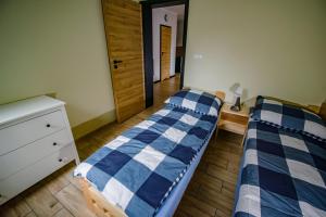 a bedroom with two beds and a dresser in it at Dębowa Przystań in Boszkowo-Letnisko