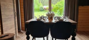 科乌切沃Domek Baltic的餐桌、椅子和一瓶鲜花