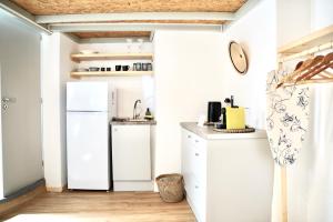 a small kitchen with a refrigerator and a sink at Èar in Ermoupoli