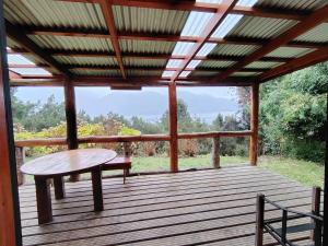a wooden deck with a table and a bench on it at Cabaña El Ulmo in Puerto Rico +46 photos
