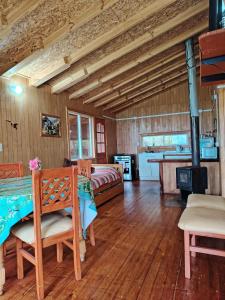 a room with a bed and a table and chairs at Cabaña El Ulmo in Puerto Rico