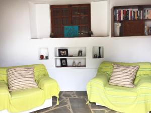 a living room with two green couches and books at Cobblers in Maroni