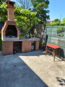 a brick oven with a red table in a backyard at Casa Tesmao in Constanţa +8 photos