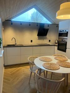 a kitchen with a table and chairs and a window at Stuga Loft Apartment Rinkaby-Åhus-Kristianstad in Rinkaby