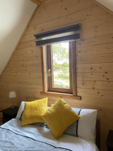 a bedroom with a bed with yellow pillows and a window at Mazurski Reset in Wilnowo