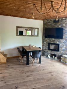 a dining room with a table and a fireplace at Mazurski Reset in Wilnowo +23 photos