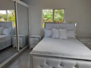 a bedroom with a bed with white sheets and pillows at Hermosa Casa en Juana Vicenta Samana in Santa Bárbara de Samaná