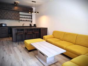 a living room with a yellow couch and a table at ORBIS Premium apartment in Nitra