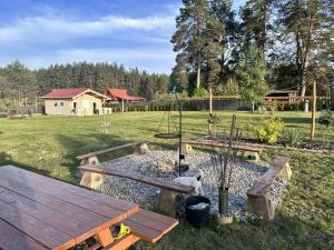 a park with a picnic table and a swing at Wczasy Pod Sosnami in Krutyń