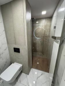 a bathroom with a shower with a toilet and a shower at Harley Quinn Apartment in Poprad