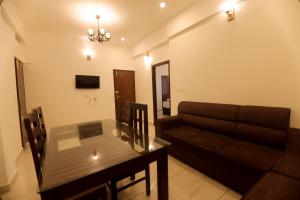 Himasailam Pool Resort Vagamon في فاغامون: غرفة معيشة مع أريكة وطاولة