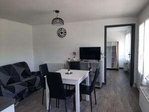 a living room with a white table and chairs at Appartement T1 bis proche centre ville in Figeac