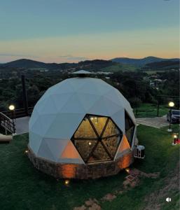 a dome tent sitting on top of a grass field at Estância Janela Natural in Lambari