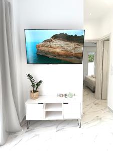 un salon avec une télévision sur un mur blanc dans l'établissement Sueno de luz Corfu, à Áfra