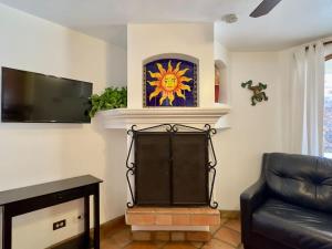 a living room with a fireplace and a tv at Puerto Nuevo Surf Casita del Arte 1BR with pool in Raulis