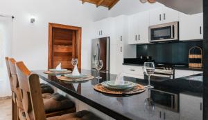 a kitchen with a table with wine glasses on it at Villa Anyelina Hotel boutique in Sánchez