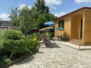 a patio with an umbrella and chairs and a house at Mana Home777 in Zugdidi
