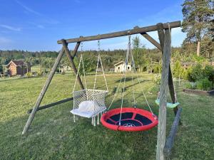 a swing with a chair and a wheel at Wczasy Pod Sosnami domek z kominkiem in Krutyń