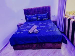 a bed with a blue comforter and two slippers on it at Nour D'asilah 3 in Asilah +28 photos