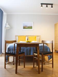 a dining room table with yellow pillows and a bed at Apartament Studio 208 in Biała Podlaska +27 photos