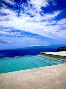 a swimming pool with a view of the ocean at Elysium Exclusive Villas in Áyioi Saránda