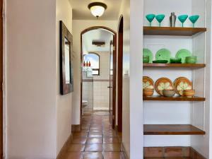 a hallway with plates and bowls on shelves at Puerto Nuevo Surf Casita de Mimbre 1BR with pool in Raulis +11 photos
