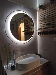 a bathroom with a sink and a round mirror at Konitsa Primula in Konitsa