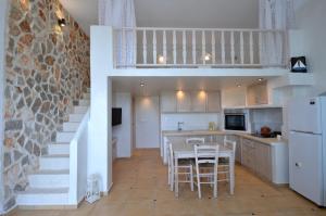 una cocina con escalera, mesa y sillas en Kathara Bay Apartments en Faliraki