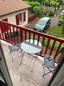 a table and chairs on a balcony with a car at Appartement proche gare in Tonneins