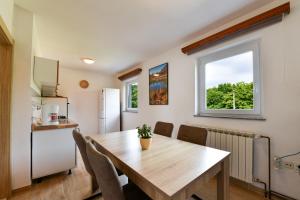 a kitchen and dining room with a table and a refrigerator at Apartman Babara in Seliste Dreznicko