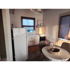 a kitchen with a white refrigerator and a table at Alos in Ammouliani +21 photos