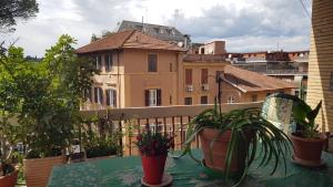 a balcony with a table and potted plants and buildings at Casa Dorianna in Rome