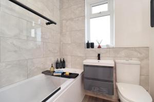 a bathroom with a tub and a toilet and a sink at Cowpen Lodge in Stockton-on-Tees +7 photos