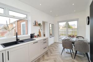 a kitchen with a sink and a table with chairs at Cowpen Lodge in Stockton-on-Tees