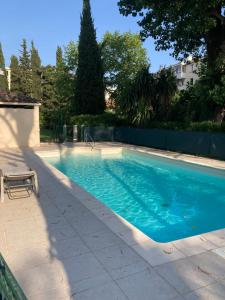 a swimming pool with blue water in a yard at Studio cuisine parking piscine à Cannes in Cannes